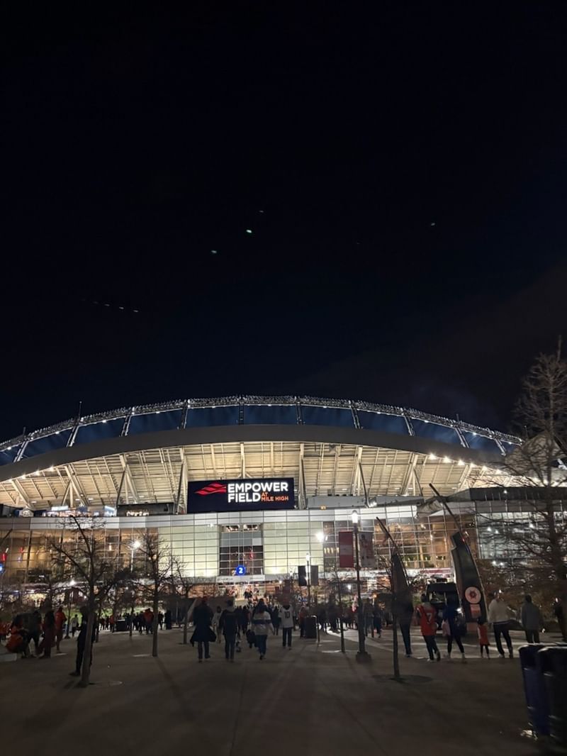 Broncos Stadium at Mile High by bright lights under a dark night in near Warwick Denver