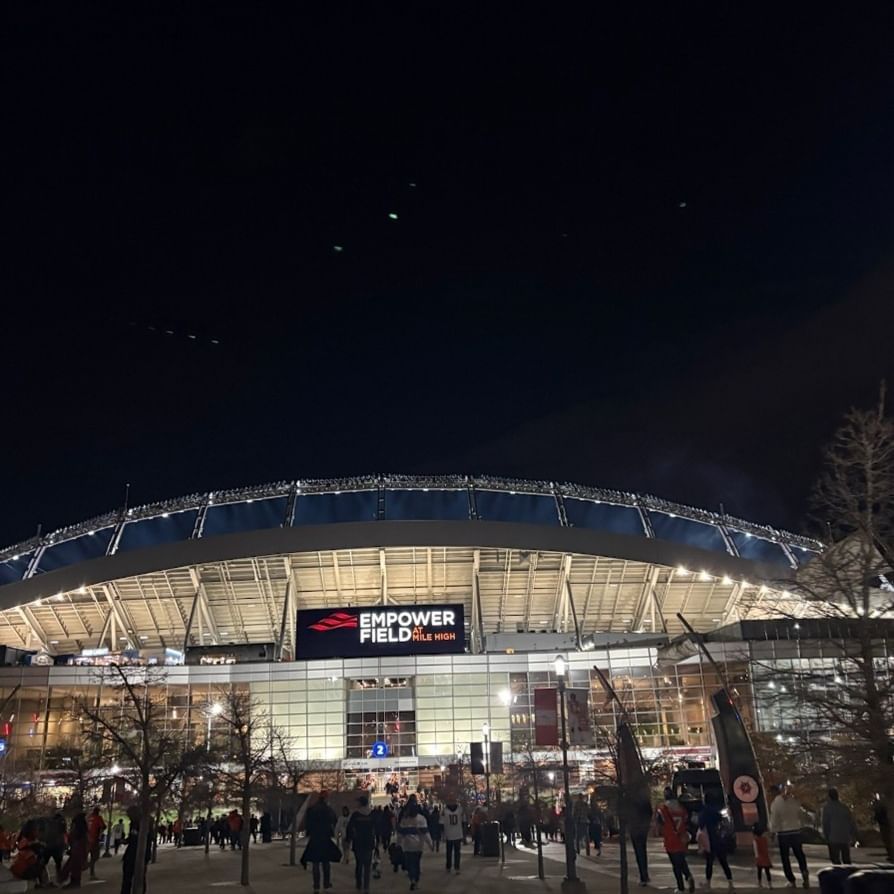 Broncos Stadium at Mile High by bright lights under a dark night in near Warwick Denver