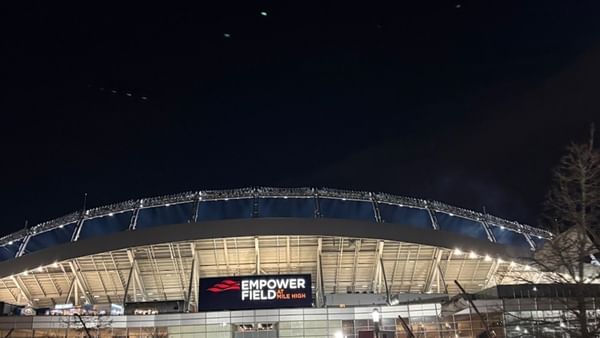 Broncos Stadium at Mile High by bright lights under a dark night in near Warwick Denver