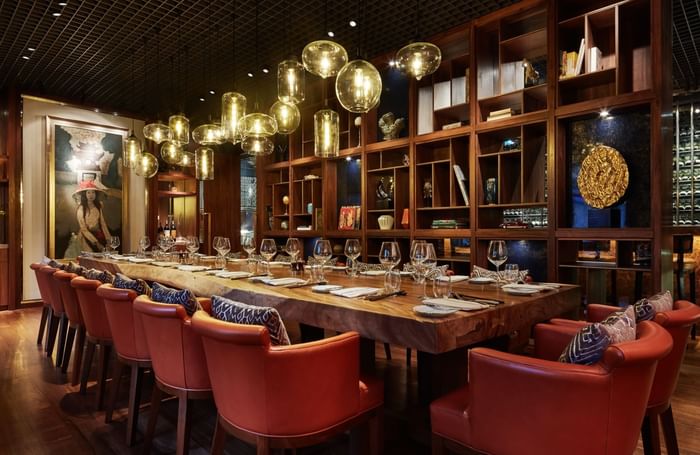 Long dining table arranged with glassware & candle lights in Square One Restaurant at Park Hyatt Saigon