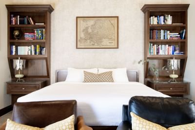 King bed, bookshelf & comfy chairs in King Premiere room at Retro Suites Hotel