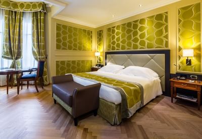 King bed, comfy sofa, bedside cupboards & lamps in Deluxe King Room at Grand Visconti Palace