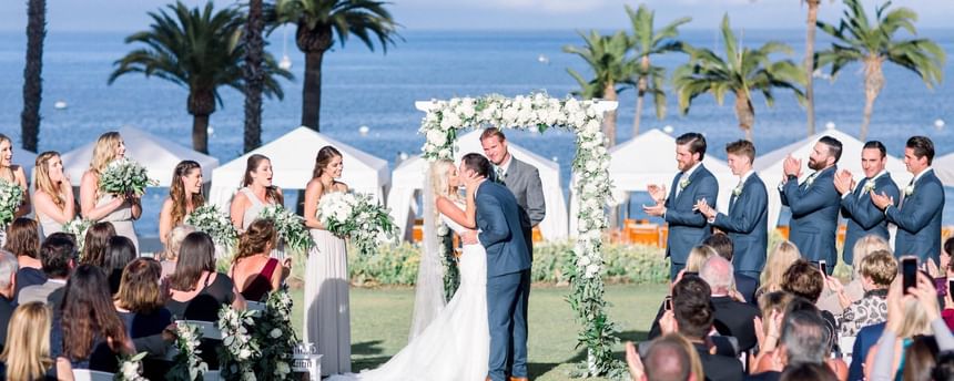 Landscape view a wedding ceremony arranged outdoors with a ocean backdrop at Catalina Island Company