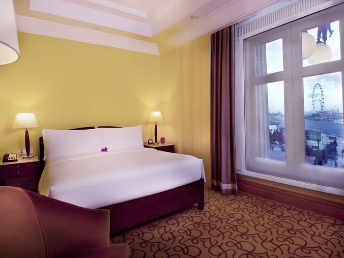 Marina Bay View Room with king bed and a sofa at Fullerton Singapore