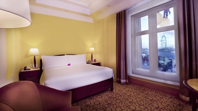 Marina Bay View Room with king bed and a sofa at Fullerton Singapore
