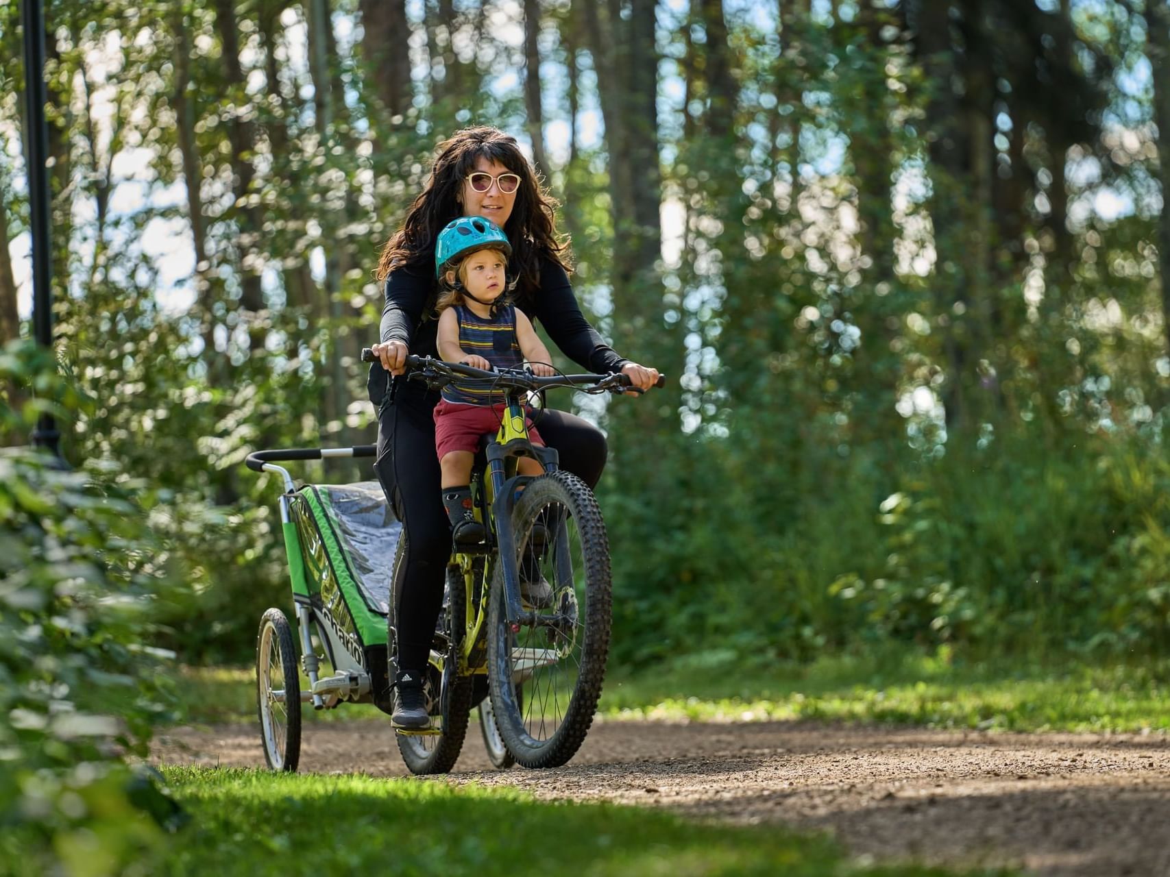 Mother & child cycling together on a running track near Merit Hotel & Suites, featuring things to do in Fort Mcmurray Canada