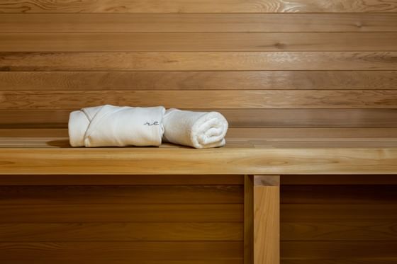 Robe & towel folded on a sauna bench at ReStays Ottawa