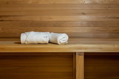 Robe & towel folded on a sauna bench at ReStays Ottawa