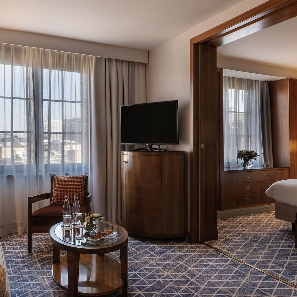 Warwick Suite TV lounge featuring a sofa near the bed with an ottoman at Warwick Grand Place Brussels
