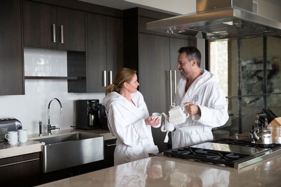 A couple pouring a morning coffee in the kitchen at Stein Eriksen Residences