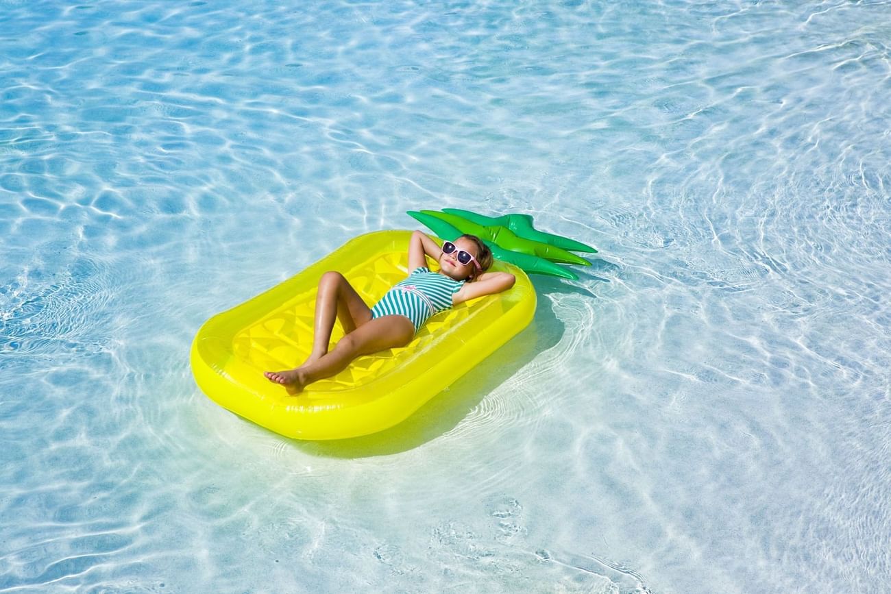 Kid sleeping on a floating tube in a pool at The Grove Resort and Water Park