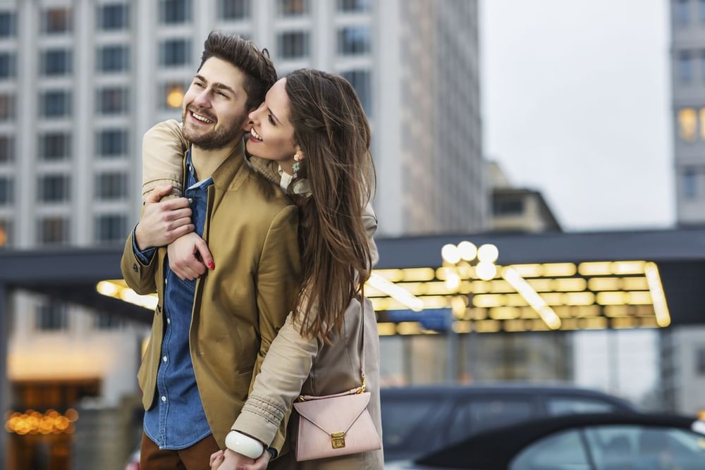 Woman hugging boyfriend from behind in city