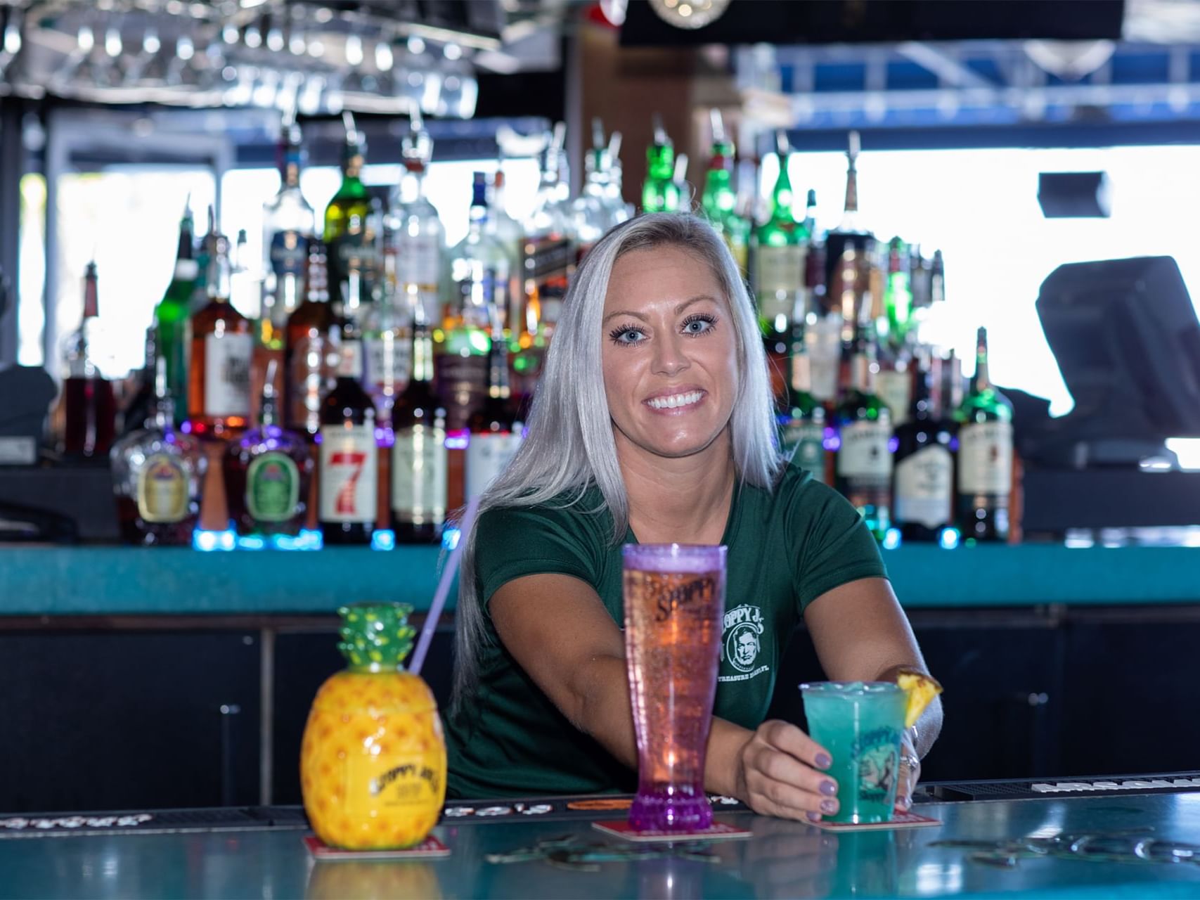 Waitress serving cocktails by the bar counter in Sloppy Joe's at Bilmar Beach Resort