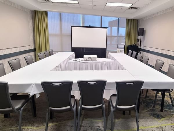 Meeting venue with project screen, chairs, and long tables