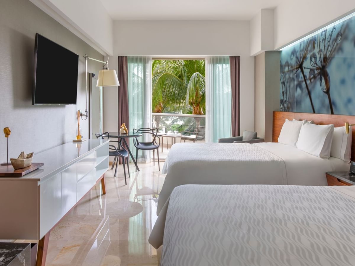 Two double beds with arranged seating and TV in Premium Partial Ocean View room at Live Aqua Cancún