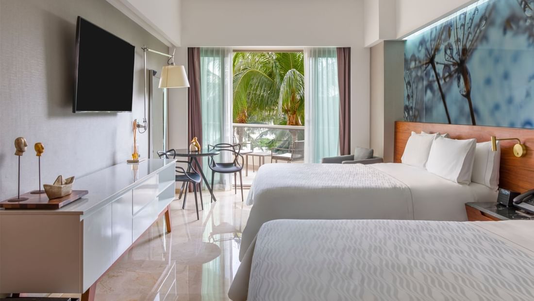 Two double beds with arranged seating and TV in Premium Partial Ocean View room at Live Aqua Cancún