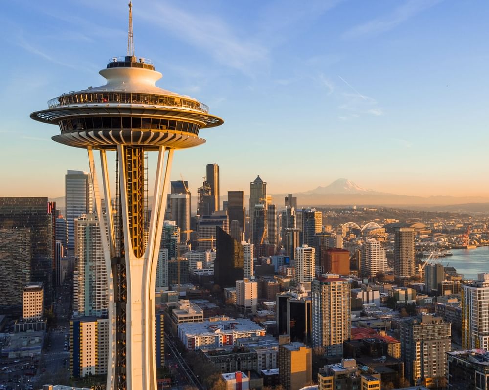 The Space Needle by the city skyline and harbor under a golden sunset near Warwick Seattle