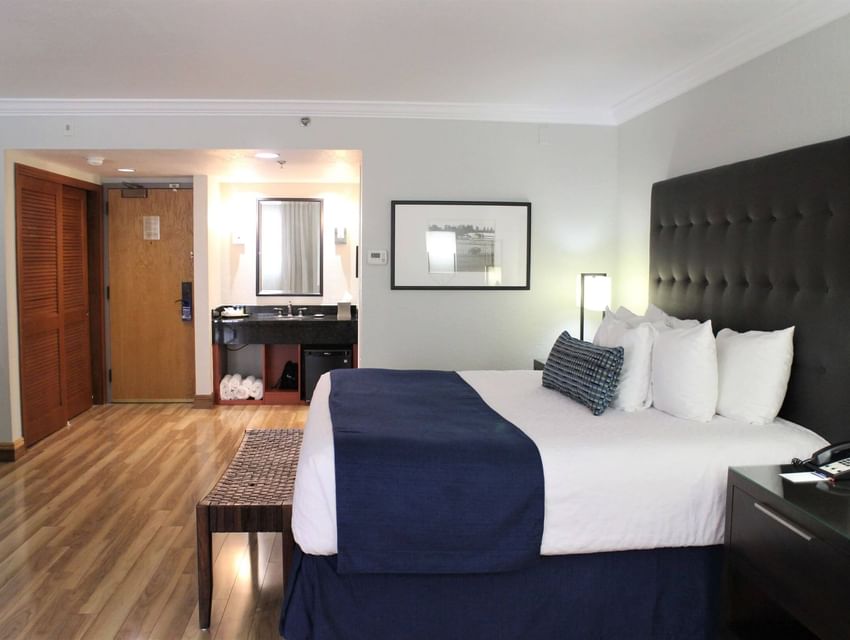 King bed and room vanity in Junior Suite with wooden floors at Miami Lakes Hotel
