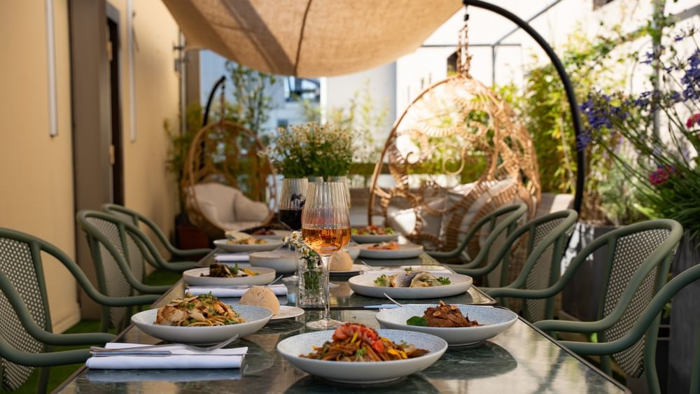 Table dressée avec plats gastronomiques sur la Terrasse Le W au Warwick Paris Champs-Elysées