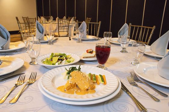 Mesa de banquete con platos gourmet y cristalería dispuestos en el salón de baile de Araiza Calafia