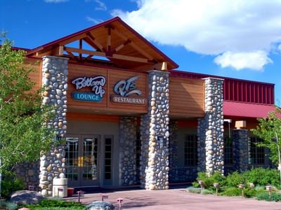 Bottoms Up Lounge and QT's Restaurant building with stone pillars and a red roof at Buffalo Bill Village