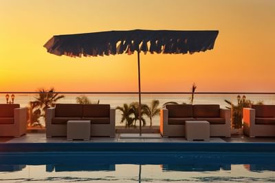 Loungers by the outdoor pool in Ocean Place at Sunset