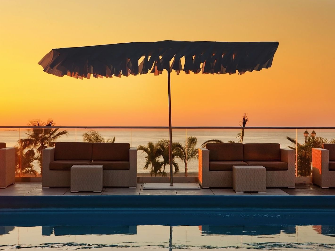 Loungers by outdoor pool in Ocean Place & Spa at Sunset