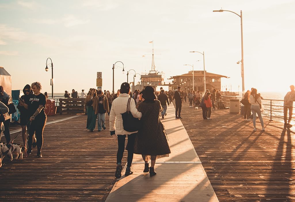 couple walking on Stearns Wharf at sunset