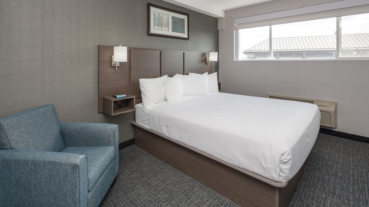 Room with bed, chair, and window.