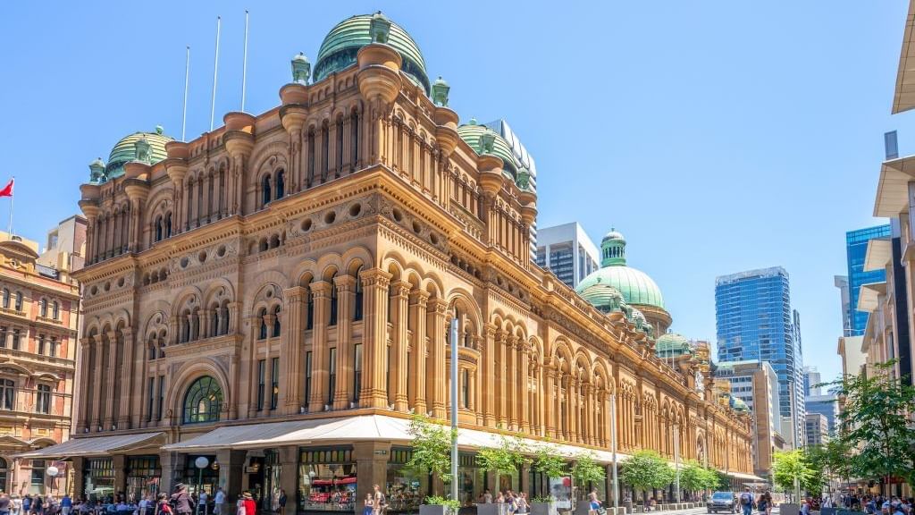 The historic Queen Victoria exterior with people and trams ear Novotel Sydney on Darling Harbour