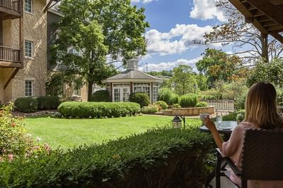 Lady having drink with courtyard view, The Herrington Inn & Spa