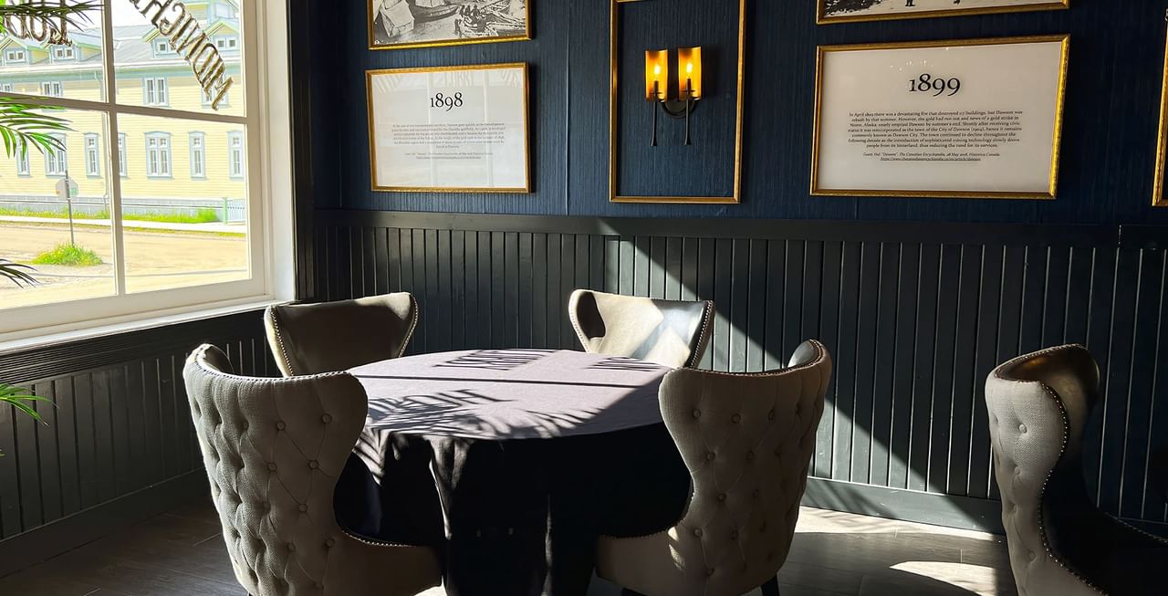 Table set-up by a wall of vintage photos at Midnight Sun, a Coast Hotel
