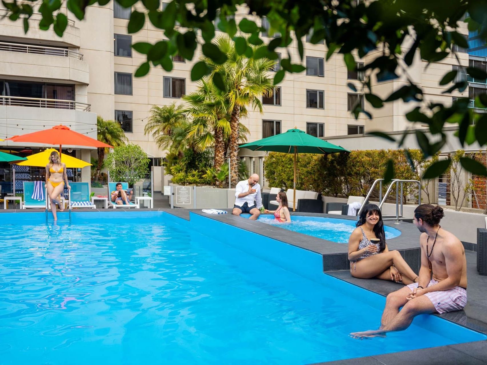 People lounging by the outdoor swimming pool at Grand Chancellor Adelaide