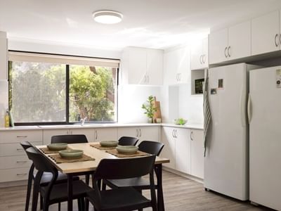 Dining area with table and chairs, large window, and modern kitchen at UniLodge at Curtin University - Erica Underwood House.