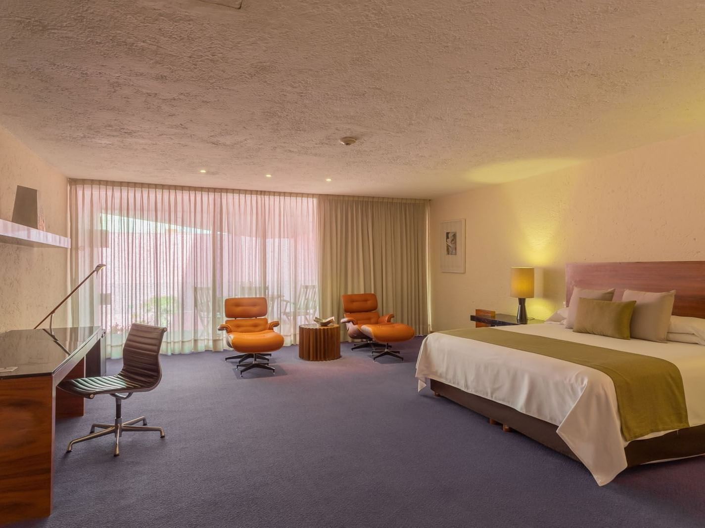 King Chapultepec Suite with two leather armchairs, a work desk, and purple floors at Camino Real Polanco Mexico