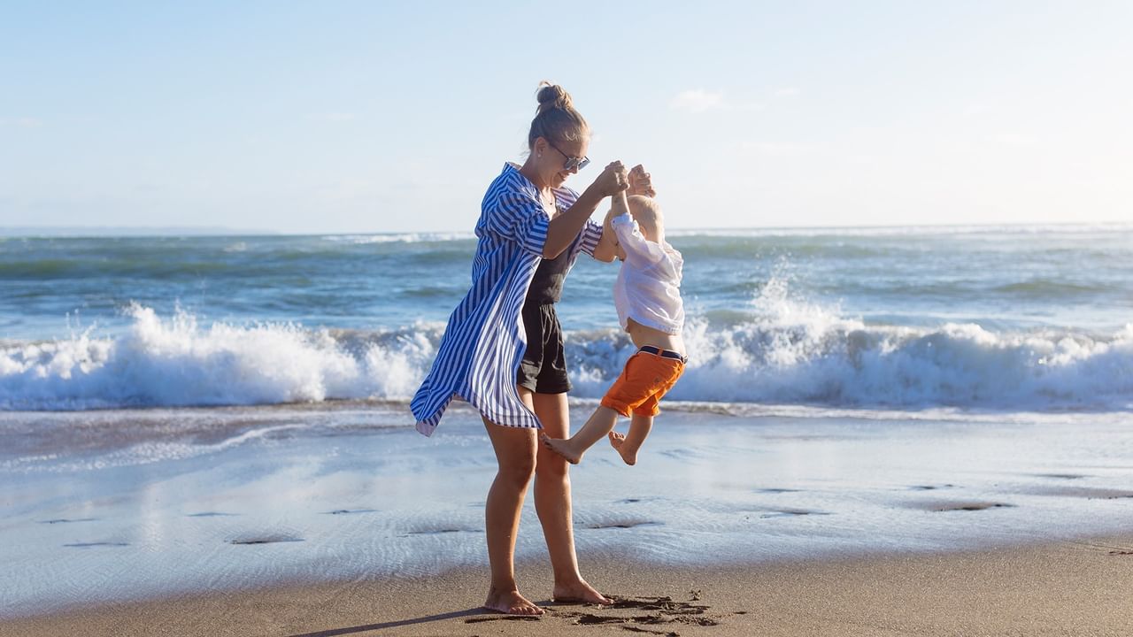 Mother and child playing on the beach.