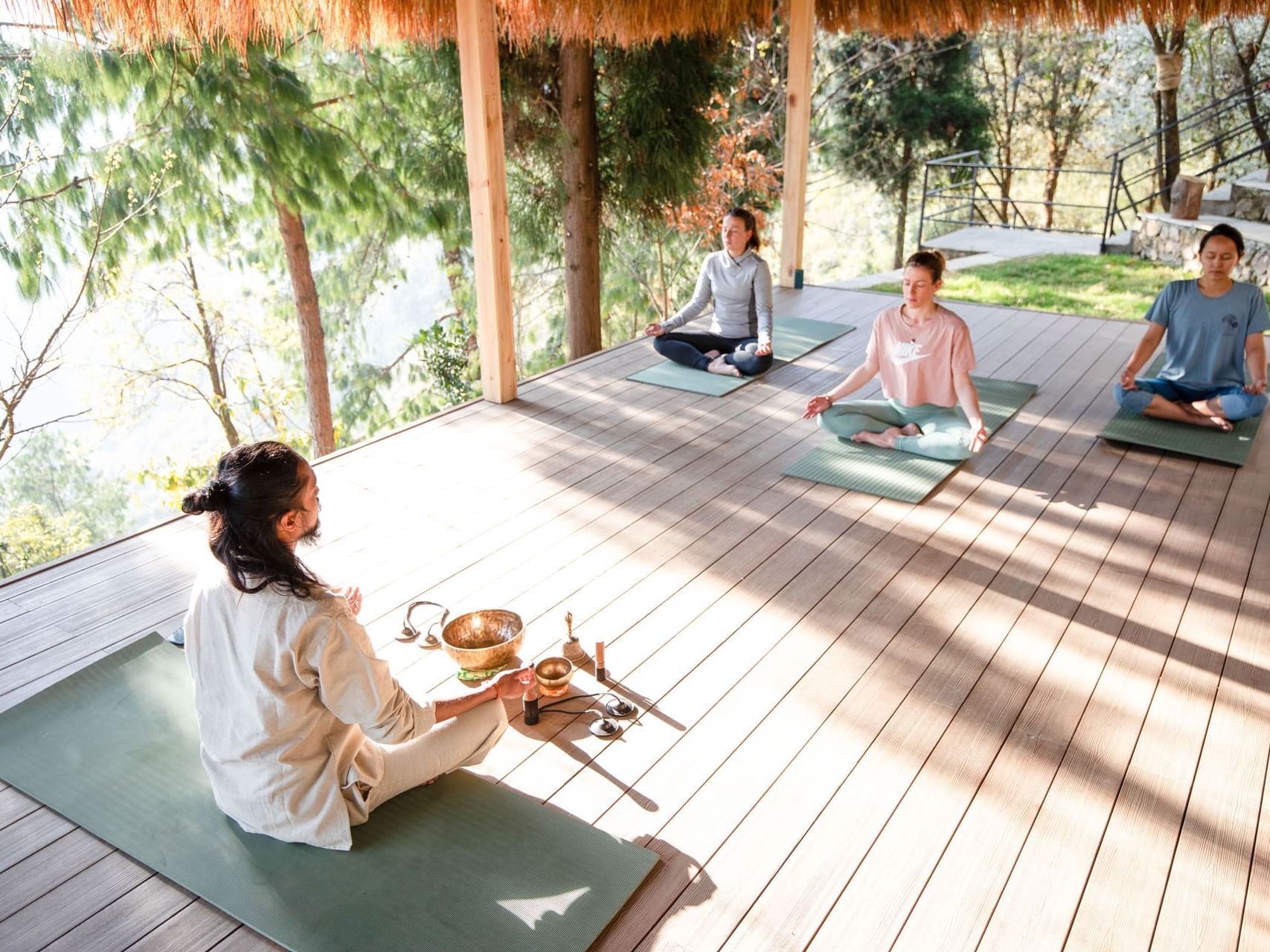 People practicing meditation on mats in a serene outdoor setting at The Terraces Resort & Spa