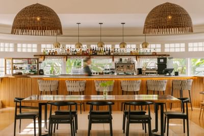 Art Deco restaurants in Miami, Seasons Cafe with woven dome lights and a long table at Kenmore Village Hotel South Beach