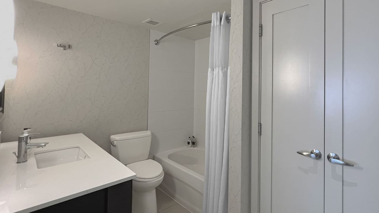 Bathroom with toilet, sink, bath and cupboard