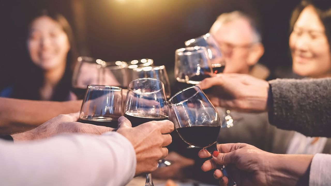 group of friends cheering with wine glasses