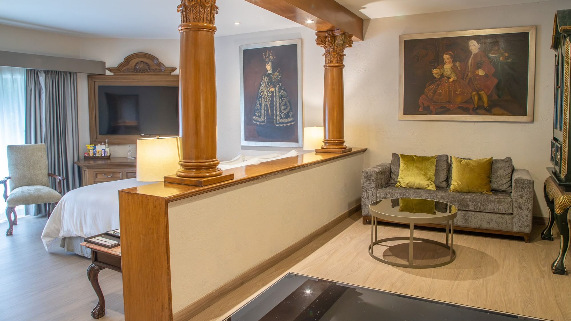 Suite Gobernador King con columnas decorativas, sala de estar y arte colonial en Quinta Real Guadalajara
