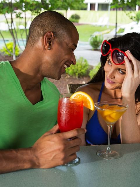 Couple gazing at each other while enjoying drinks from Tanlines Bar & Grill at Cove Pocono Resorts