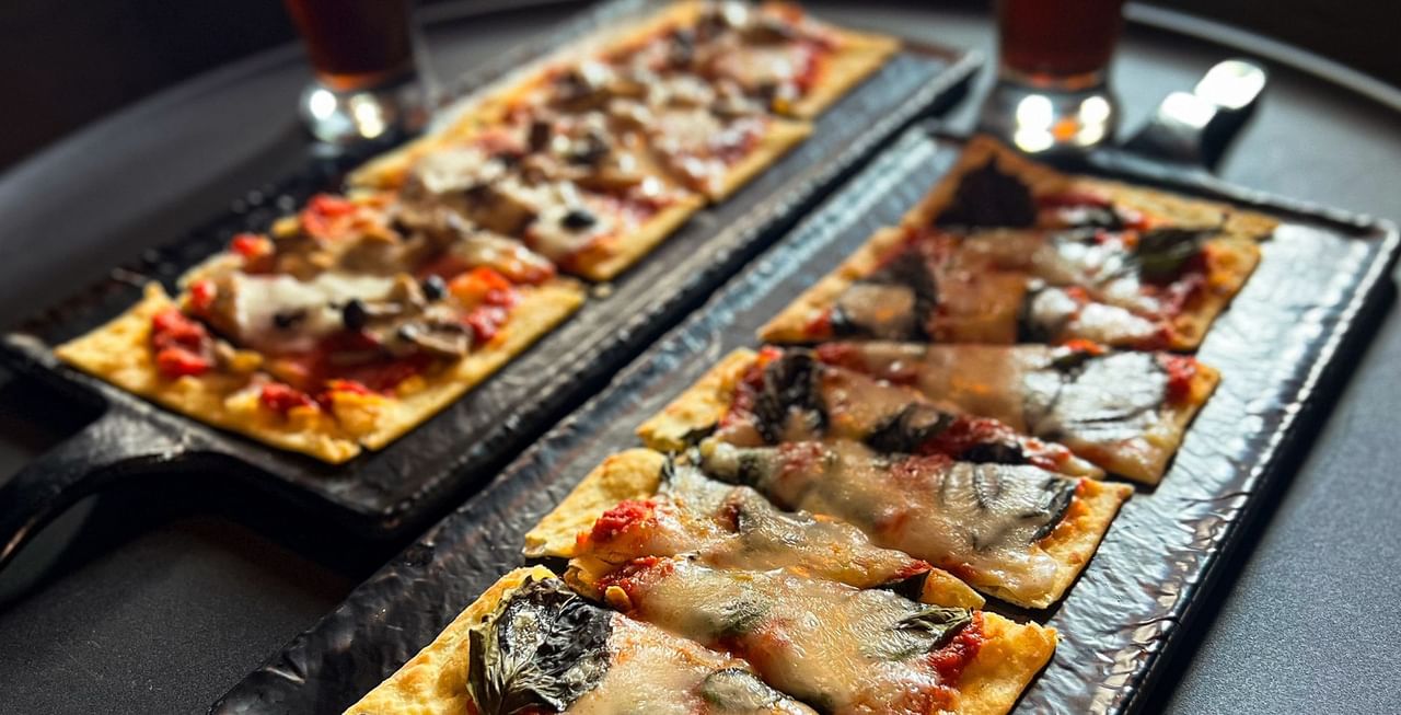 Close-up of flatbread and beer served at Midnight Sun, a Coast Hotel