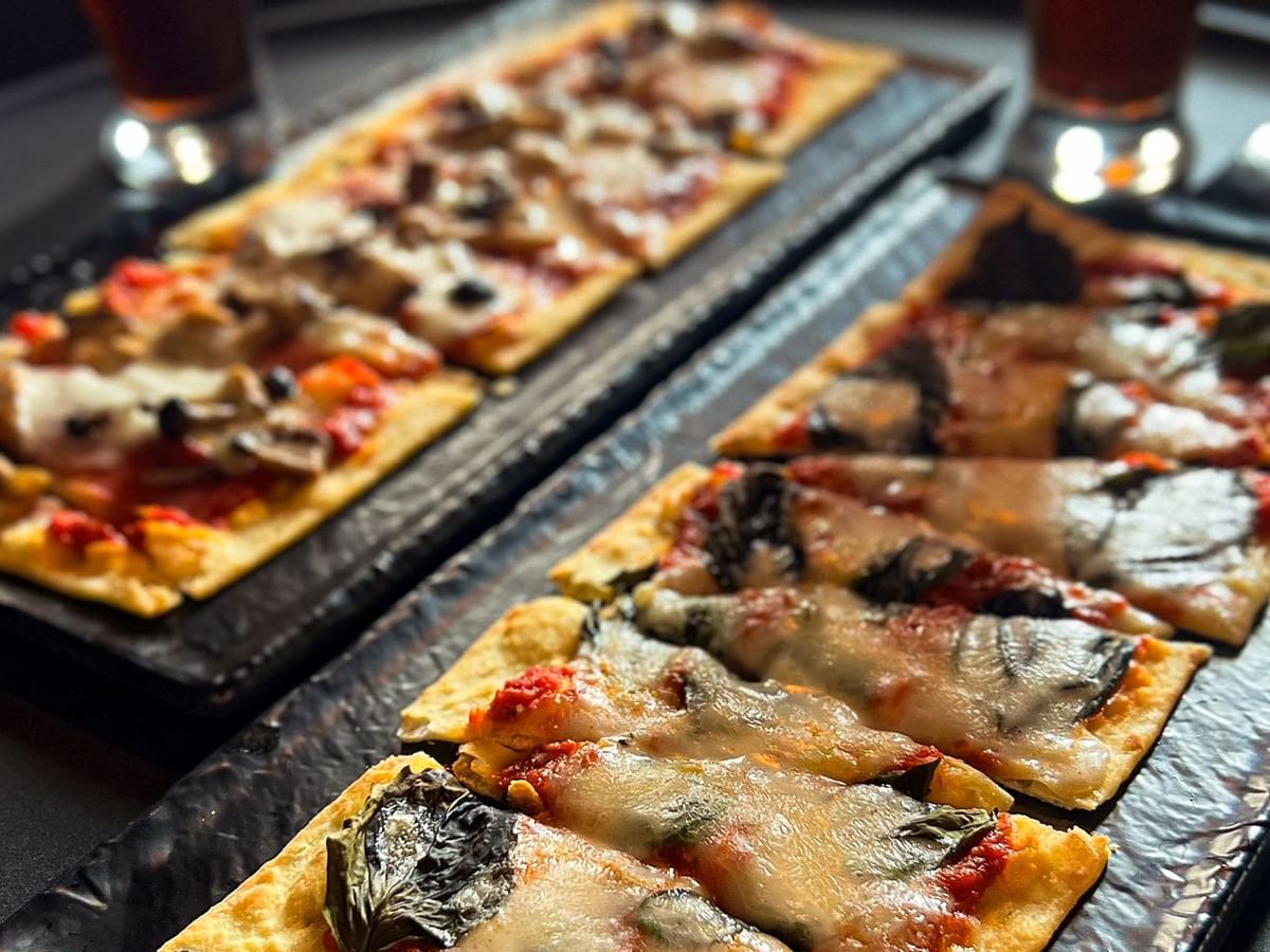 Close-up of flatbread and beer served in Midnight Sun Lounge at Midnight Sun, a Coast Hotel