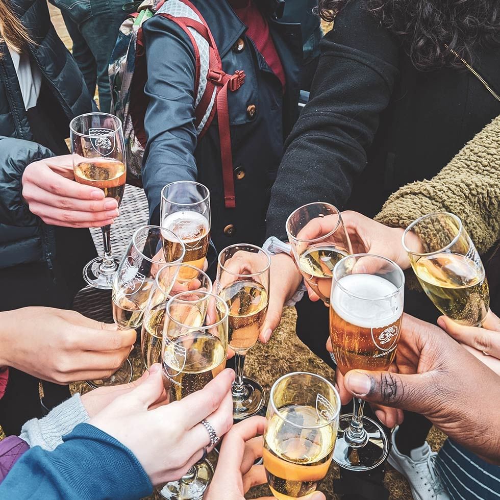 Close-up of friends toasting beer at Falkensteiner Hotels