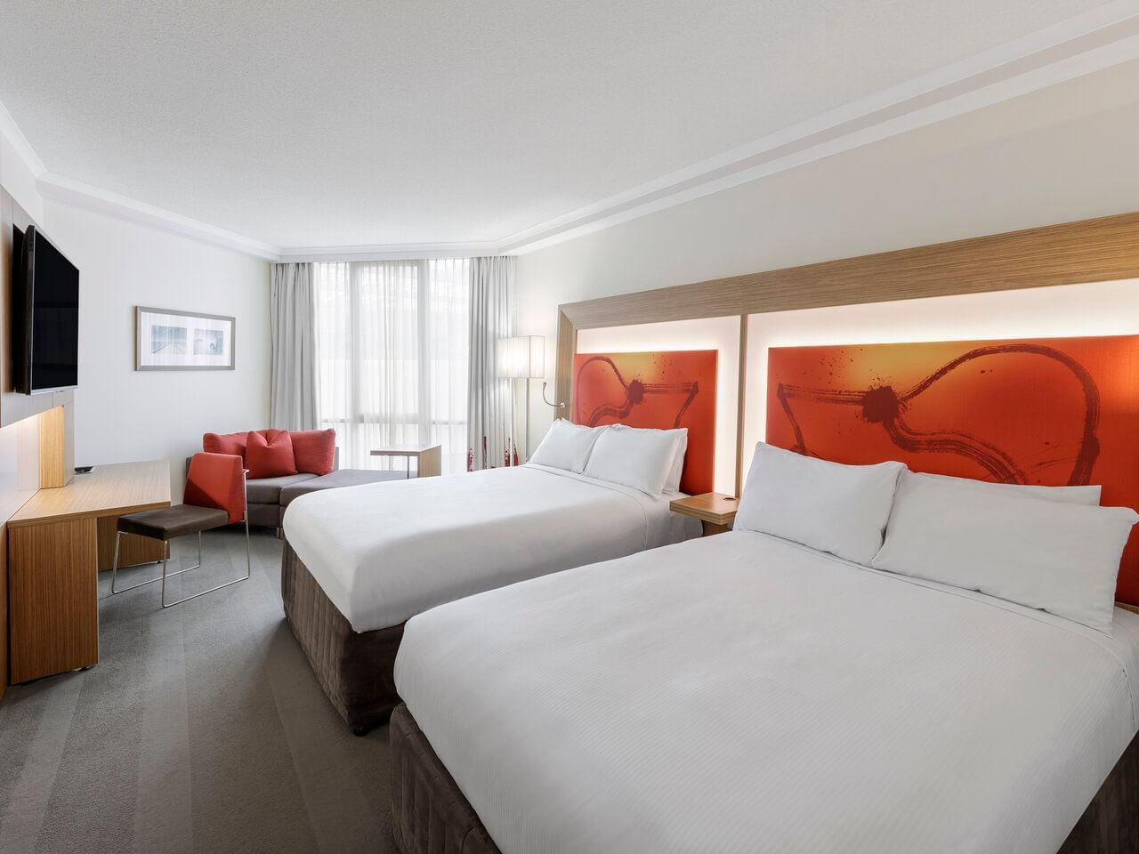 Bed, sofas & TV in Standard Double Twin Room at Amora Hotel