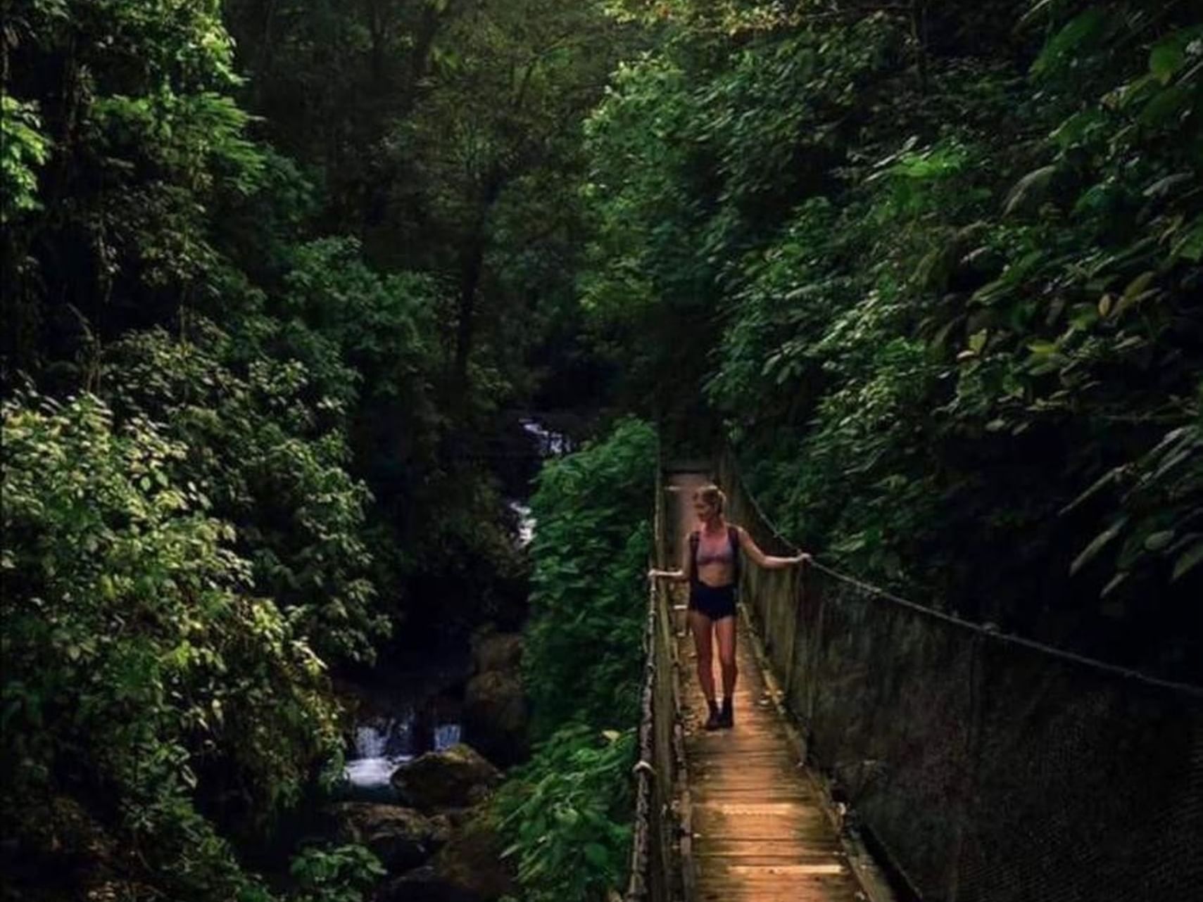 Lady overlooking the stream from a wooden bridge near Jungle Vista Boutique Hotel