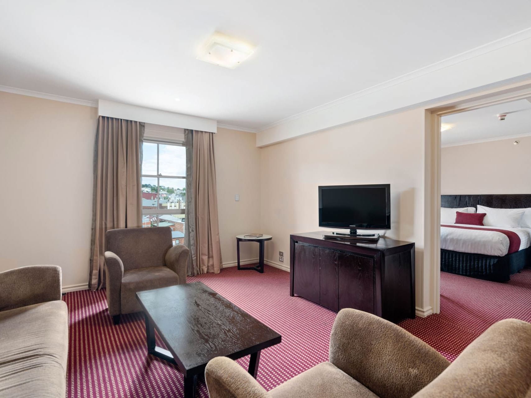 TV stand by the comfy lounge in One Bedroom Suite at Grand Chancellor Launceston