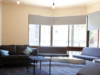 Comfortable lounge area with sofas and coffee table at La Trobe University - Orde House.