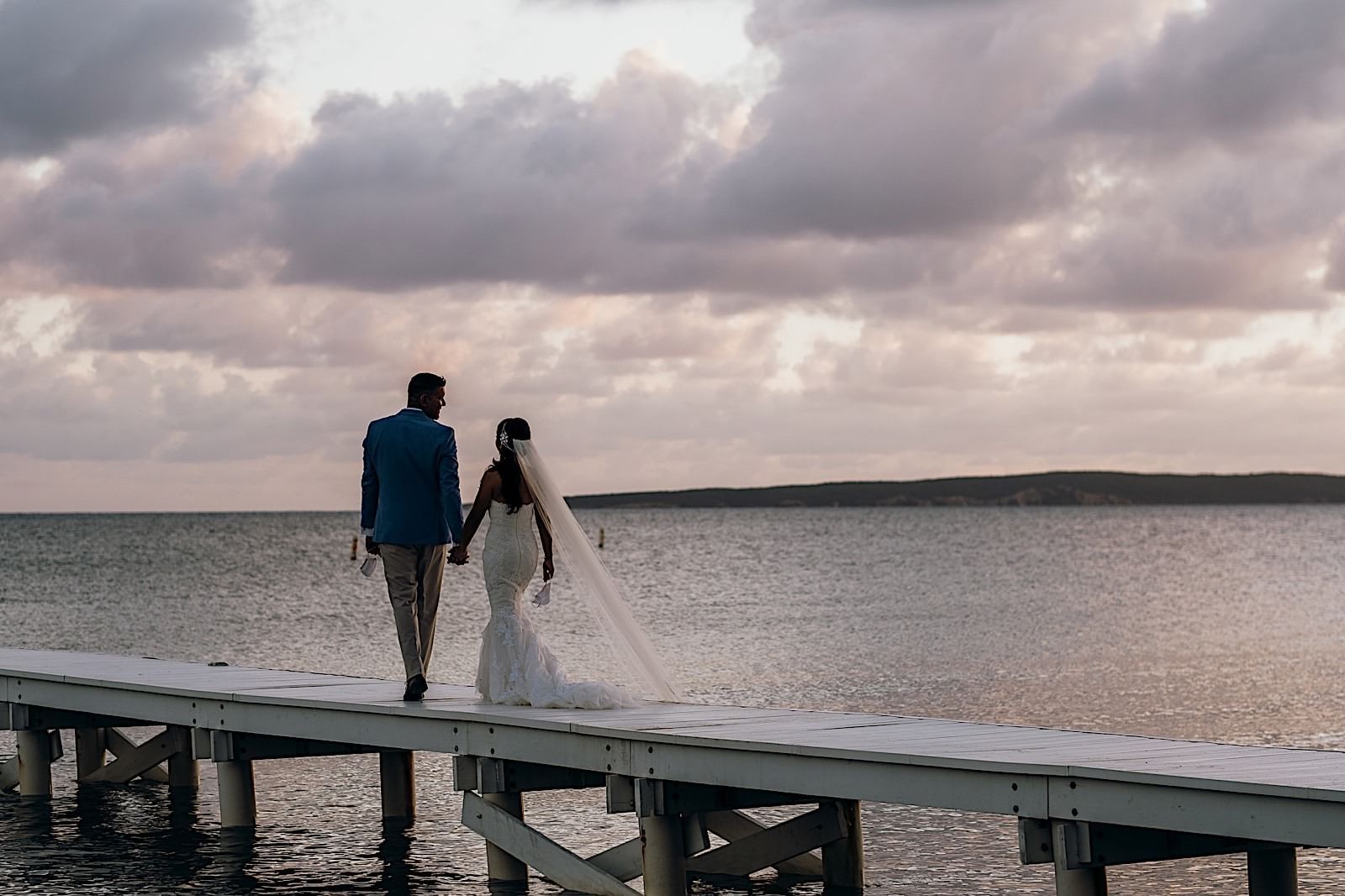 Newlyweds walking on a bridge at Copamarina Weddings